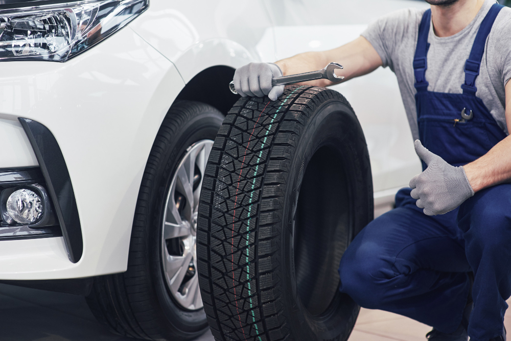 technician with blue workwear holding wrench tire while showing thumb up 1